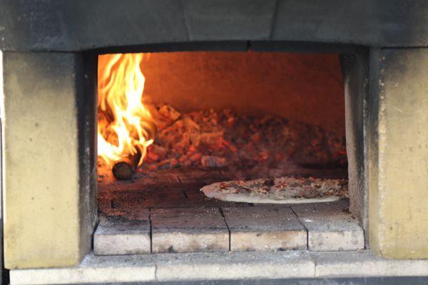 Our wood-fired pizza oven at work!