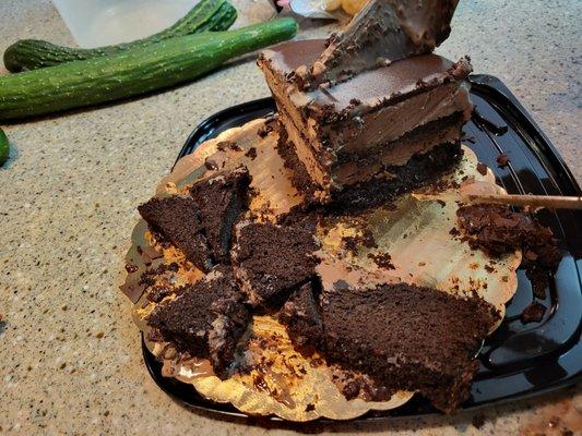 My husband is cutting the ice cream  removing stale devil's cake as he  transfer it to other container.  Half of $43 cake is wasted.