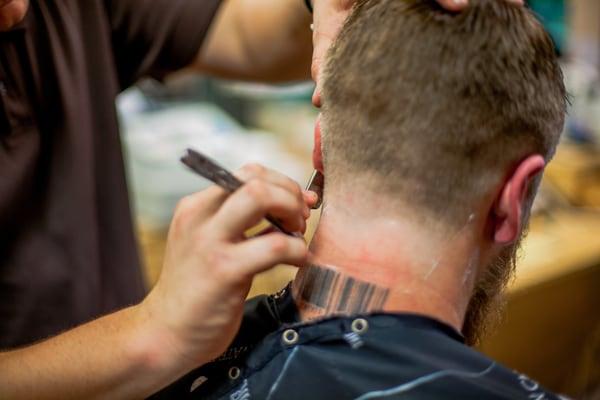 Cleaning up neck with straight razor.