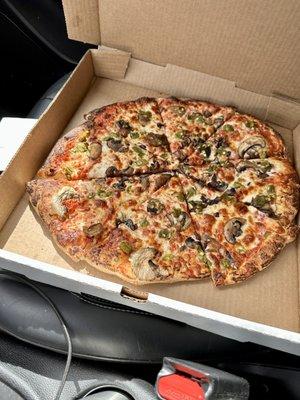 A pizza in a box, sitting on a car seat.