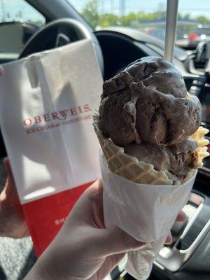 Double scoop of chocolate marshmallow on a plain waffle cone