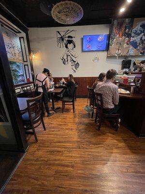 View of the available tables on the left and the sushi bar on the right. The entrance is in the foreground on the left.