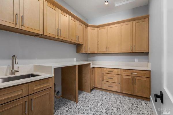 Beautiful laundry room cabinets and top designed ,supplied and installed by The Cabinet Outlet