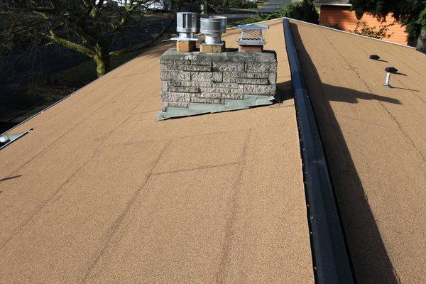 CertainTeed granulated torchdown installed by Addicott. The black metal is a continuous vented ridge allowing proper attic airflow.