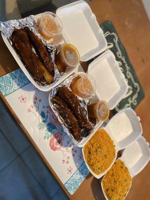 BBQ ribs and Yellow rice and green peas with side gravel and spice Haitian sauce