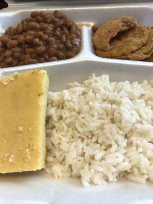 Vegetable plate containing baked beans, fried green tomatoes, rice, and cornbread