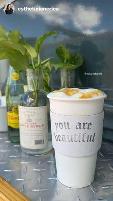 Hot Caramel Latte with propagated pothos in the background.