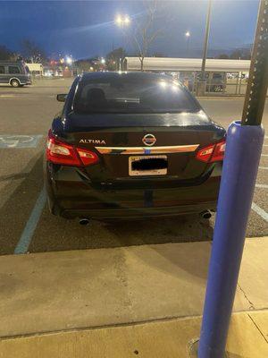 Illegally parked employee in disabled spot. You can see the disabled pole. Tags marked out for privacy.