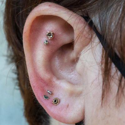 Stacked earlobe piercings and two flat piercings by Otto at IRIS Studios Portland