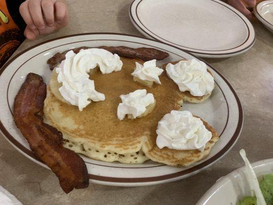 Mickie mouse pancakes with bacon, pineapple and whipped cream.