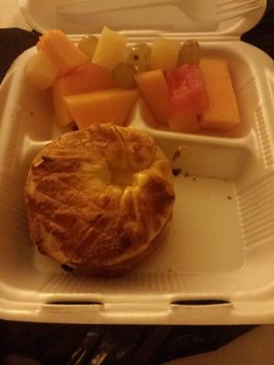 Sausage, egg and cheese on a croissant with fresh fruit