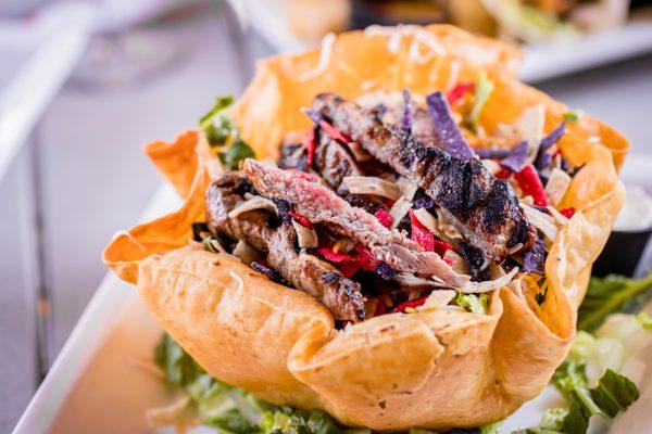 The Steak Salad prepared in a crispy flash fried tortilla shell bowl