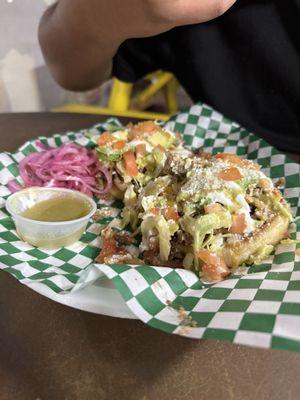 Sopes with grilled meat, cheese, lettuce, beans and sour cream with tomatoes