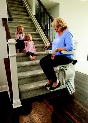 A stairway lift enabling this grandma to go upstairs to play with her grandchildren.