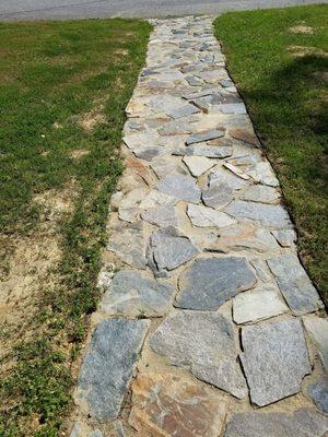 Uneven walkway with multiple tripping hazards and stones that move