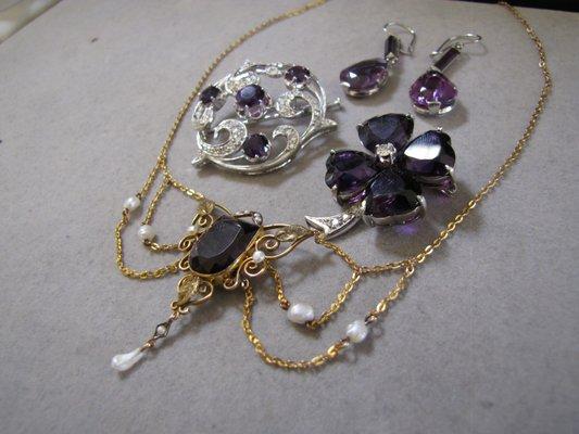 A grouping of Amethyst antique and modern jewelry in white and yellow gold.