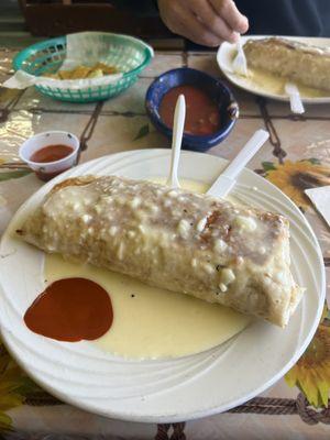 Chicken burrito covered in queso