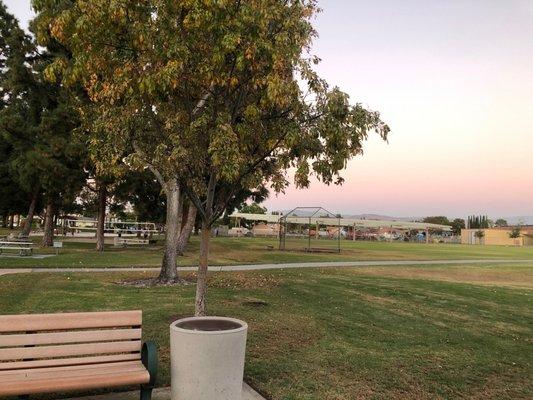 View from big kid playground to little kid playground. There's picnic tables and volleyball court in between