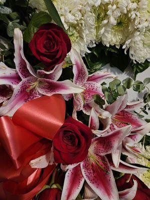 Close up of large red roses and gorgeous lilies in standing heart