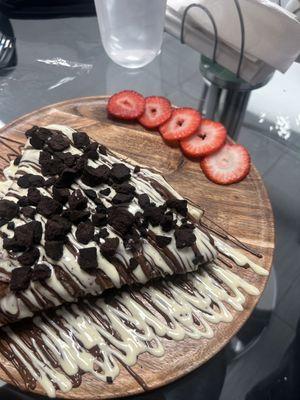 Banana and strawberry stuffed crepe with Nutella and Belgian white chocolate drizzle topped with brownies.