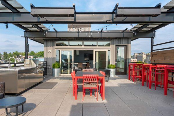 Rooftop terrace with BBQ area, overhead heaters, and lounge seating.