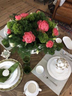 Flower arrangement with beautiful dinnerware, glassware and linens.