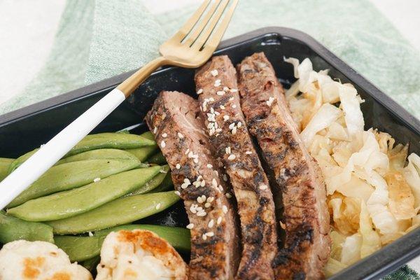 Korean BBQ Bulgogi Beef with sautéed cabbage, snap peas, and cauliflower.