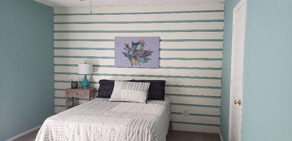 A finished painted wall with a accent wall with wood and paint