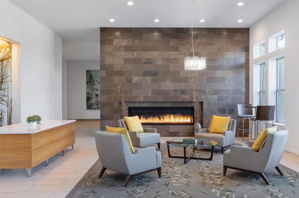 Arbour Square Lobby With Fireplace, Sofa Chairs And Glass Center Table