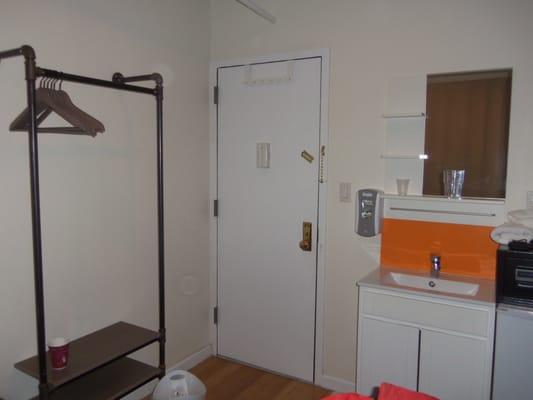 The door of our room, with clothes rod to the left and sink to right. Fridge and safe are to the right, out of picture.