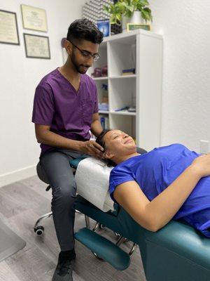 Performing cranial technique to alleviate headache and neck tension.