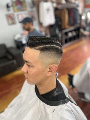 Traditional high razor fade comb over with a hard part.