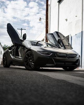 BMW i8 - Wrapped with an Aggressive Satin Black by Avery Custom Red Caliper Job Sleek Headlight Tint Lamination 5% Tint All around