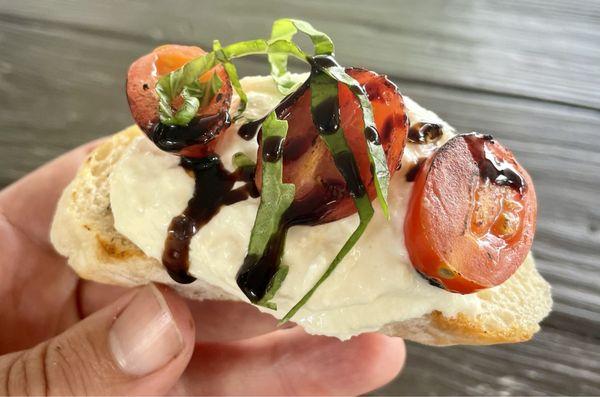 Up close look at a burrata roasted tomato crostini