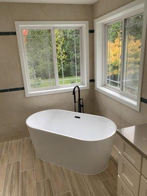 Free standing tub. Tiled walls