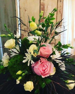 A beautiful arrangement of dianthus, roses and lisianthus in an earthy vase. Visit us or call the shop for custom-made floral designs.