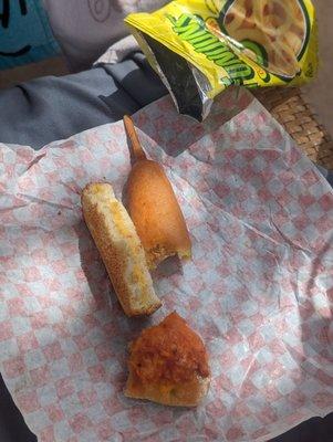 Kids lunch  half grilled cheese, half a corn dog, 1/4 slice pizza, and chips.