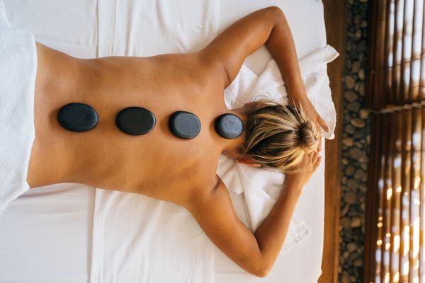 Hot stone massage helps with relaxing the muscles using heat.