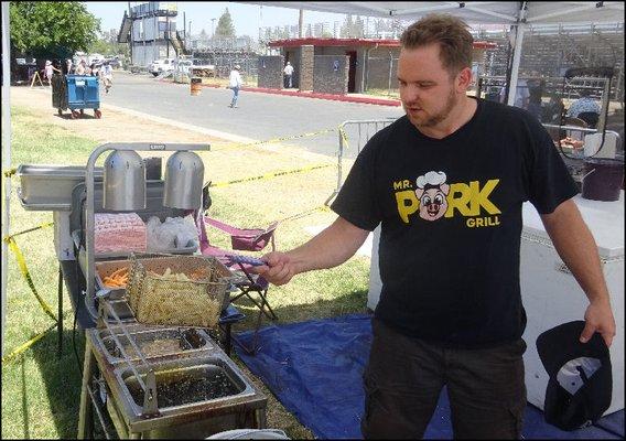 Mr. Sous Chef carefully tends the deep fryer in the back of the restaurant, lifting a basket of perfectly cooked fries out of the deep fry.