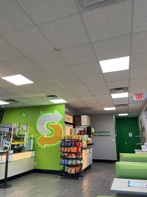 A look at the register with the chips, fountain drinks and some seats. I love the neon Subway symbol.