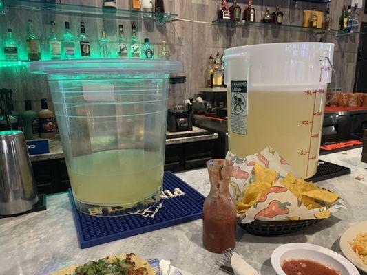 Buckets of margarita mix just setting on the bar