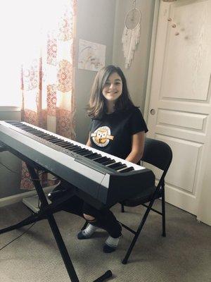 Student learning to play and sing a song together on the piano.