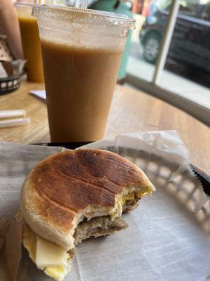 Peach smoothie and sausage, egg, and cheese on a Portuguese muffin.