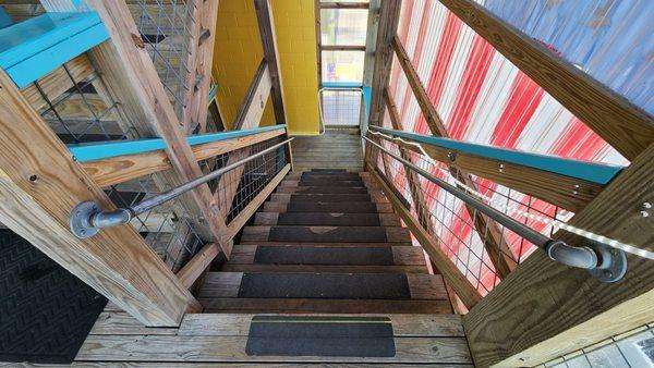 Stairs down from upstairs where bathrooms are.