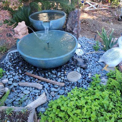 A simple pondless water feature where the water collects in a basin just below the bottom bowl and is desguised by the rocks