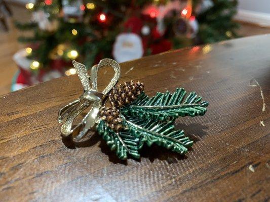 Christmas Pin with garland, pinecones and a golden bow.