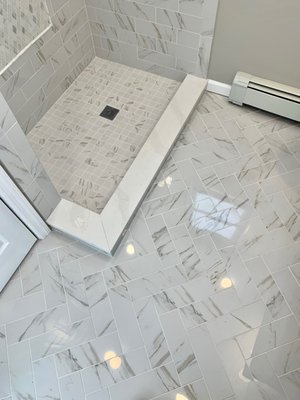 Custom floor tile custom shower pan with marble saddle or material purchased from Floor Decor