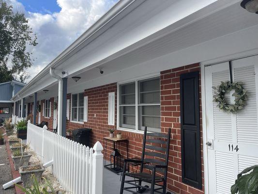 Exterior with rocking chairs and bench.