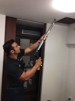 Our tech using an invasive moisture meter to check for moisture in the ceilings