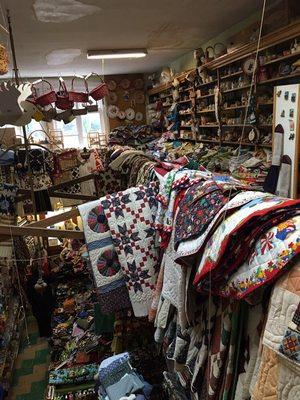 A view of the second floor which is overflowing with quilts for sale